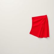 Flat lay of a red black sports skort tennis skorts Australia neatly folded on a neutral surface.