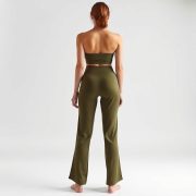 A model wearing black wide leg yoga pants seamless shorts in olive green, back view, studio shot on white background.