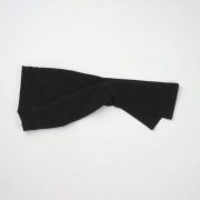 Flat lay of flare black yoga pants in charcoal, neatly folded on a neutral surface, minimalist e-commerce style.