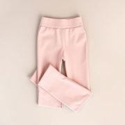 Pastel pink high waisted yoga pants flare black yoga pants folded neatly on a neutral surface, top-down view.
