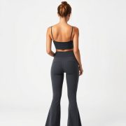 Back view of a model wearing subtle scrunch leggings flare leggings pockets in Charcoal, showcasing fit on white background.