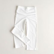 White wide leg yoga pants with scrunch bum, neatly folded on a neutral surface, minimalist flat lay.